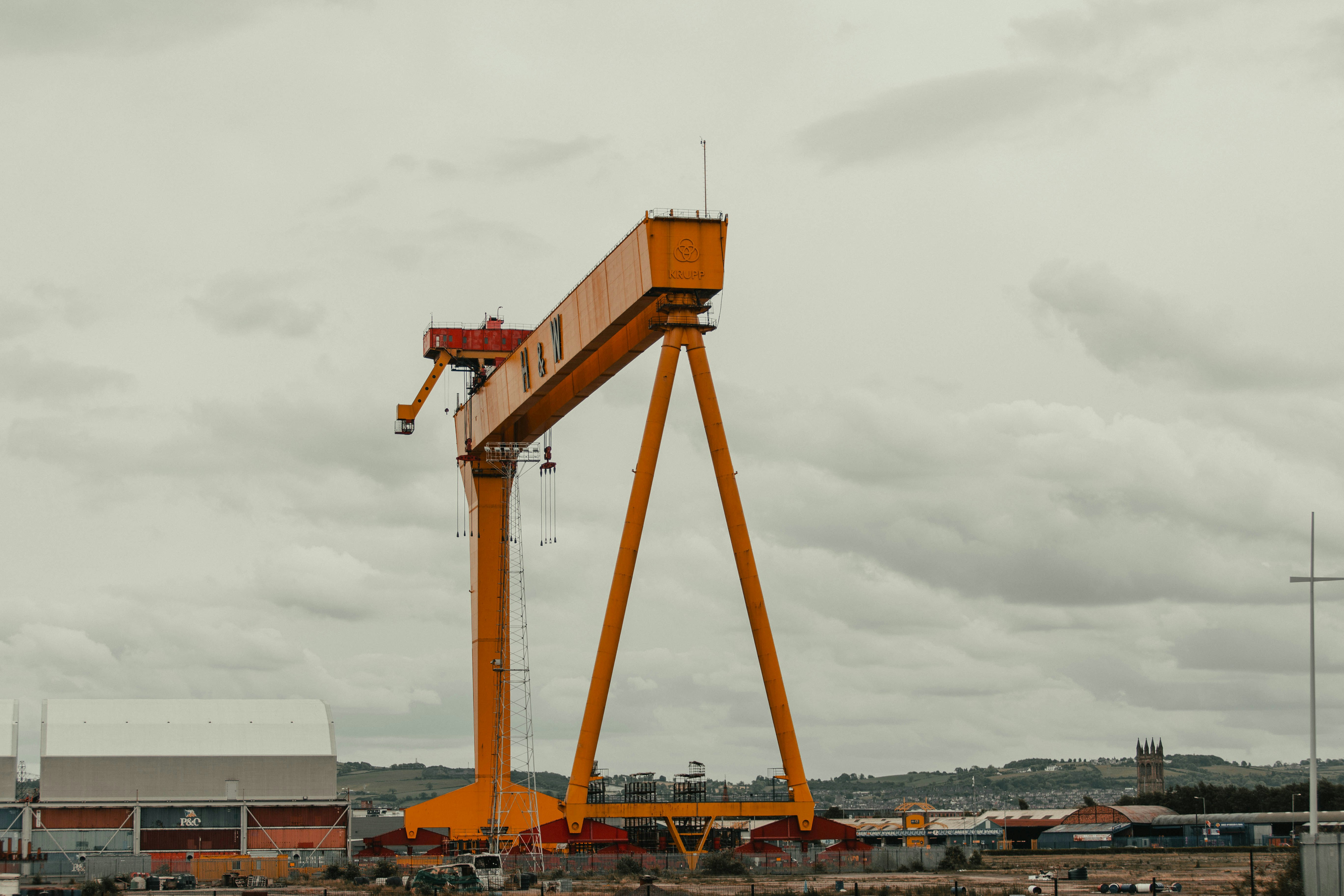 orange and white crane under cloudy sky during daytime